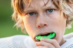 Boy with mouthguard playing football