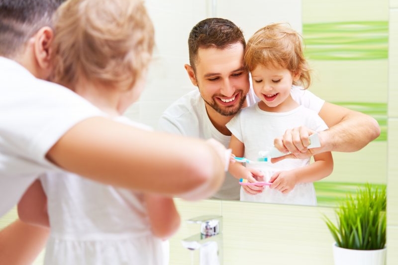 Dad Helping Kid Brush Teeth