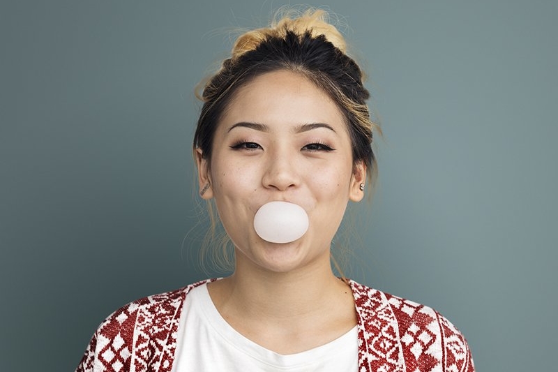 Woman Blowing a Bubble with Chewing Gum